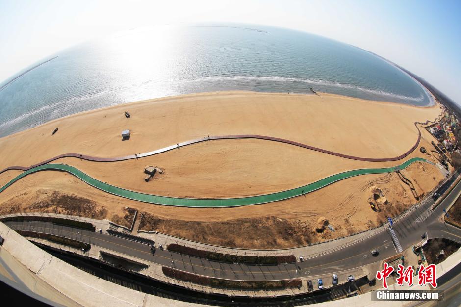 3月13日，秦皇島萬米臨海沙灘木棧道。據(jù)了解，該木棧道全長約4200米，與北戴河區(qū)原有的7500米木棧道對接后全線總長度1.17萬米，整個木棧道東起秦皇島體育基地游船碼頭，西至北戴河濕地公園，呈波浪形蜿蜒10.4公里海岸線。 中新社發(fā) 曹建雄 攝 CNSPHOTO