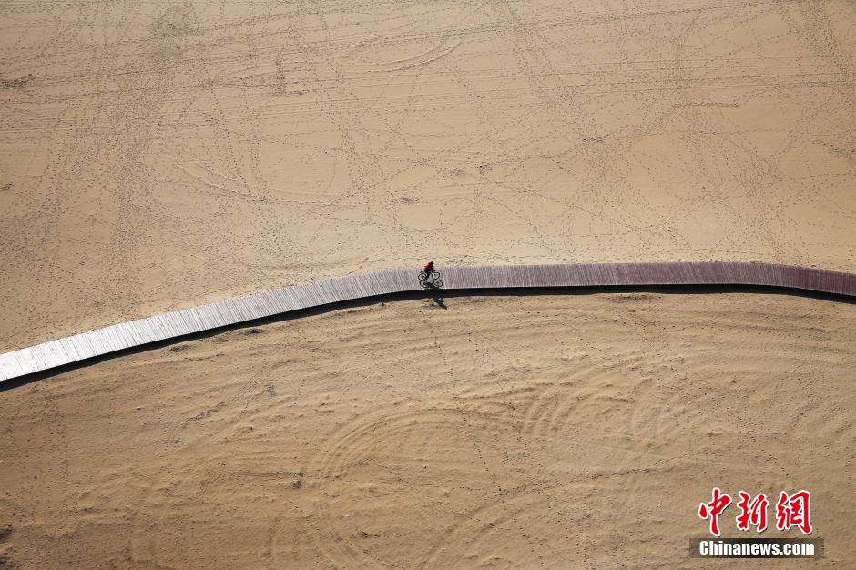 3月13日，秦皇島萬米臨海沙灘木棧道。據(jù)了解，該木棧道全長約4200米，與北戴河區(qū)原有的7500米木棧道對接后全線總長度1.17萬米，整個木棧道東起秦皇島體育基地游船碼頭，西至北戴河濕地公園，呈波浪形蜿蜒10.4公里海岸線。 中新社發(fā) 曹建雄 攝 CNSPHOTO
